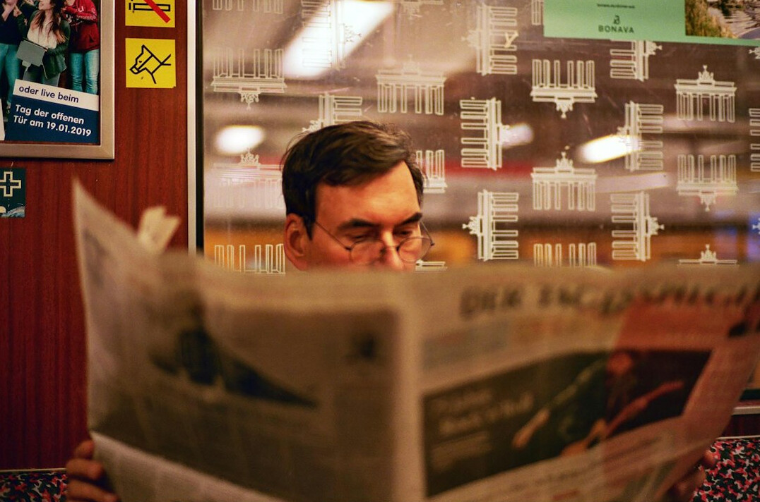 people reading newspapers with serious faces